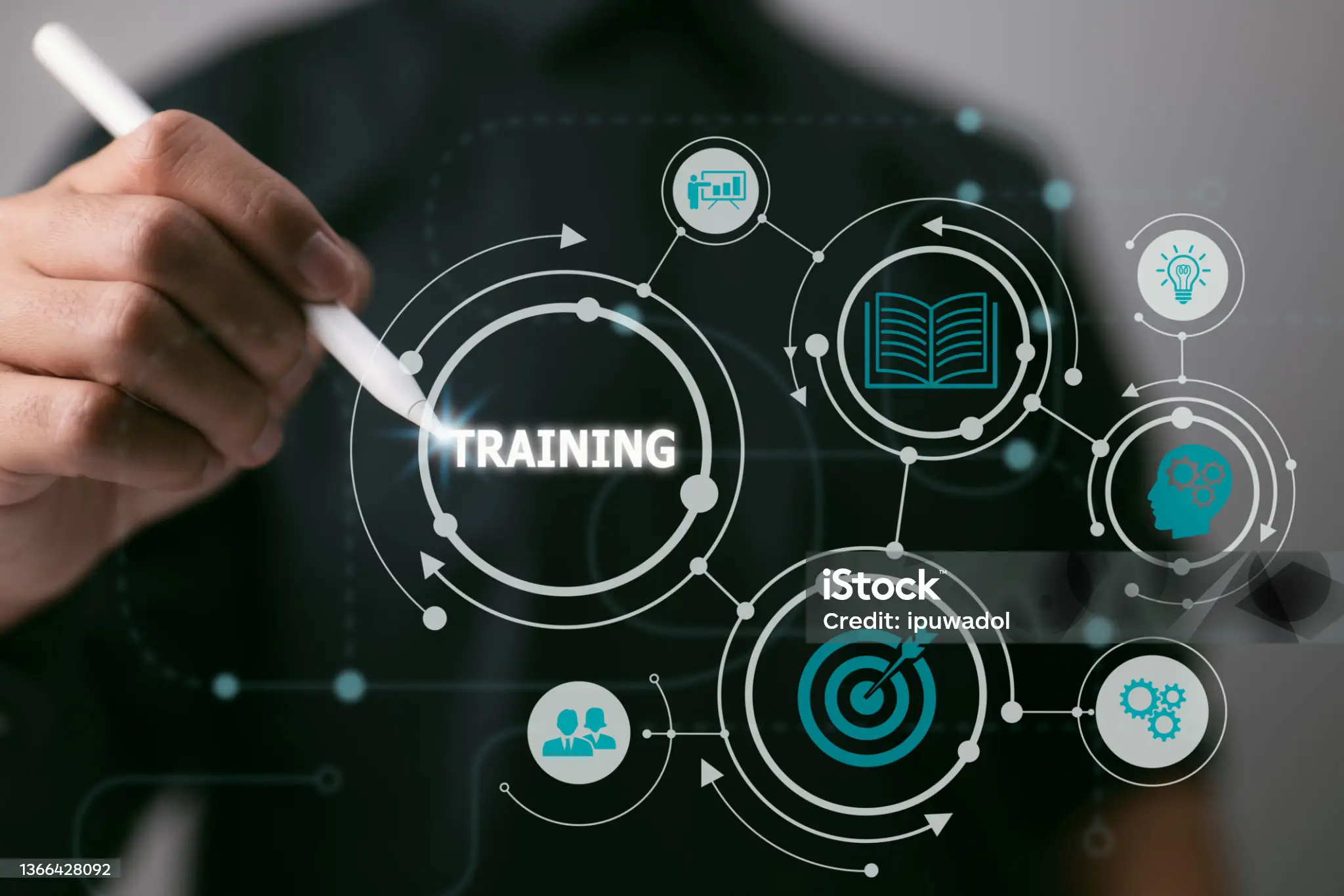 man holding a pen pointing at digital sign that says training
